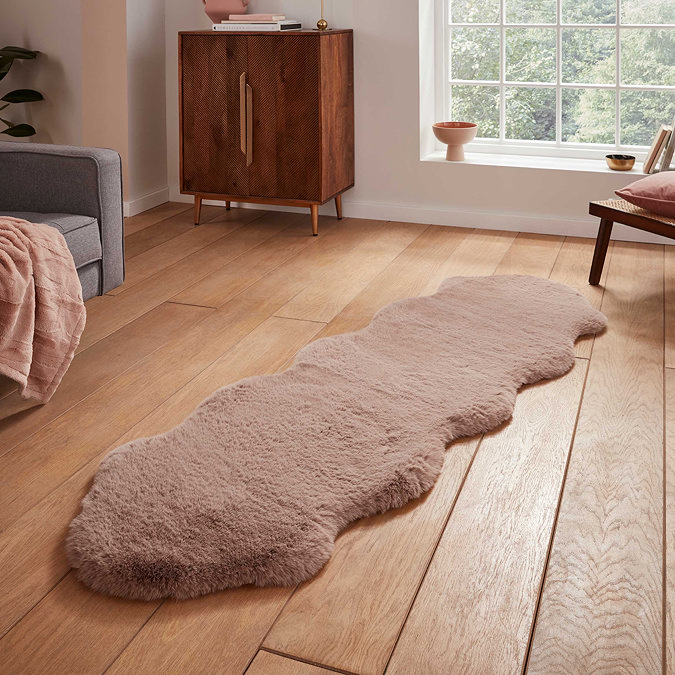 image of long mink brown soft rug on wooden flooring in front of window with natural light streaming through