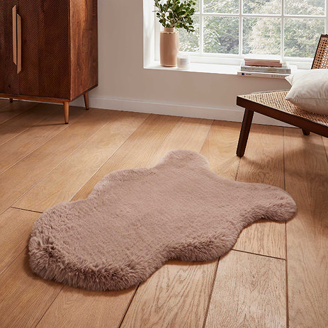 image of short mink brown sheepskin rug on wooden flooring in front of window with natural light streaming through