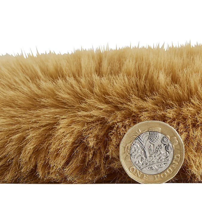 side-on image of faux sheepskin rug with pound coin stood up next to it to show rug as double the height of coin