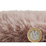 side-on image of faux sheepskin rug with pound coin stood up next to it to show rug as double the height of coin