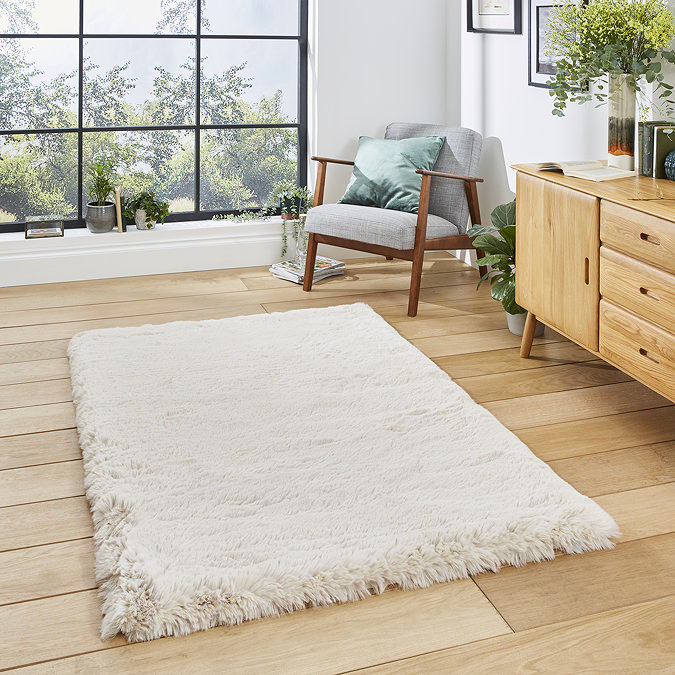 image of soft beige rug in middle of wooden flooring