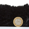 side on image of black soft rug with pound coin stood up next to it to show rug as double coin's height