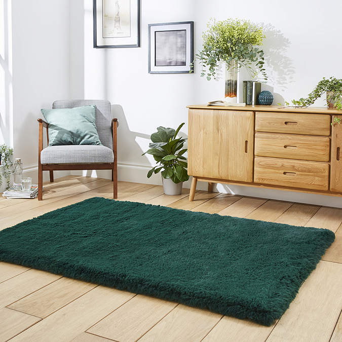 angled image of emerald green soft rug on light wooden flooring