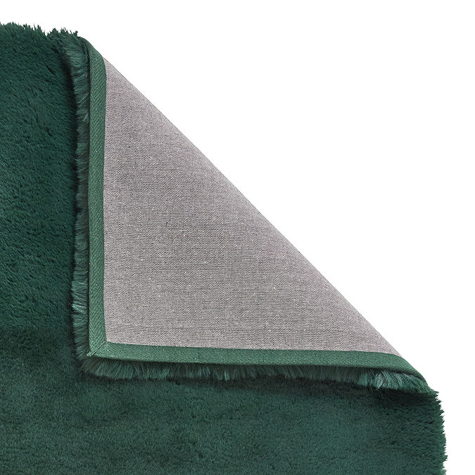 image of emerald green soft rug with corner folded over to show floor-facing material underneath