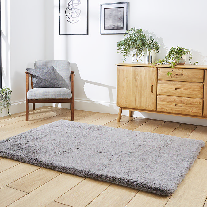 angled image of soft grey rectangle rug on wooden flooring