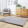 angled image of soft grey rectangle rug on wooden flooring