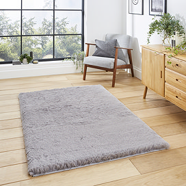image of soft grey rug on wooden flooring in front of wooden sideboard