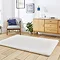 angled image of soft ivory rug on light wooden flooring in front of sideboard