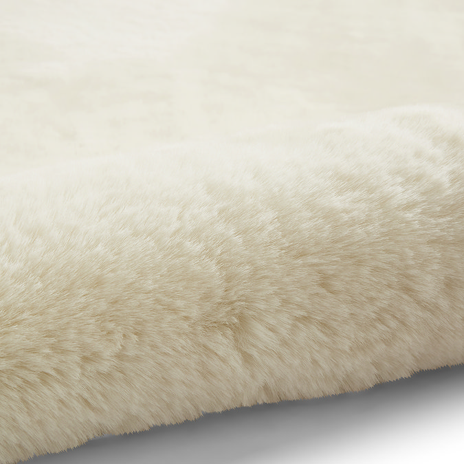 close up image of soft ivory rug rolled up on one end