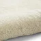 close up image of soft ivory rug rolled up on one end