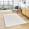 image of ivory rug on light wooden floor in front of wooden sideboard
