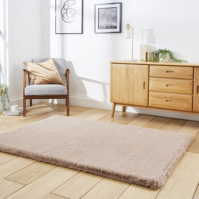 angled image of soft mink brown rectangle rug on wooden flooring in front of wooden sideboard