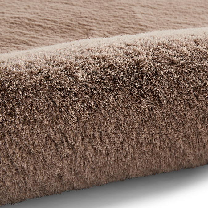 close up on mink brown soft rug rolled up on one end
