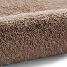 close up on mink brown soft rug rolled up on one end