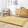 image of mustard yellow soft rug on light wooden flooring in front of sideboard