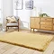 image of mustard yellow soft rug on light wooden flooring in front of sideboard