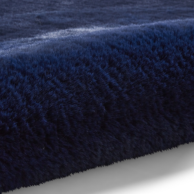 close up image of navy blue soft rug rolled up at one end
