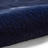 close up image of navy blue soft rug rolled up at one end