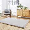 angled image of soft silver rectangle rug on wooden flooring in front of wooden sideboard
