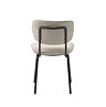 image cut out on white background of off-white fabric dining chair, taken from the back to show black metal support