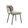 side on image cut out on white background of off-white fabric dining chair with black metal legs and back support