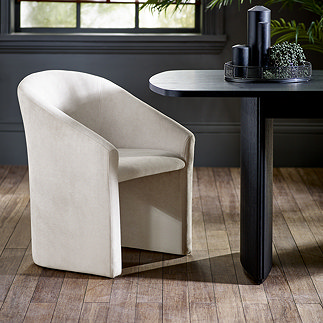 image of cream upholstered accent chair on light wood flooring under black dining table