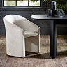 image of cream upholstered accent chair on light wood flooring under black dining table
