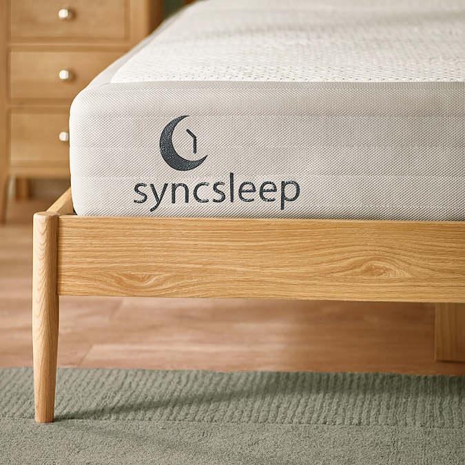 close up on bottom of double wooden bed with corner of mattress stitched with syncsleep branding