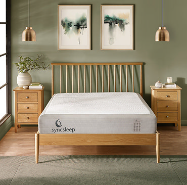 close up on bottom of double wooden bed with corner of mattress stitched with syncsleep branding