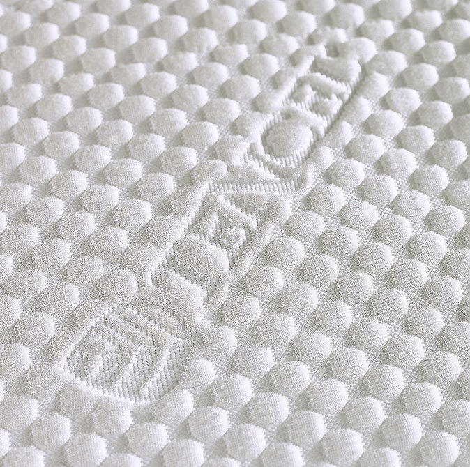 close up image on white bobbled tencel material of top of mattress