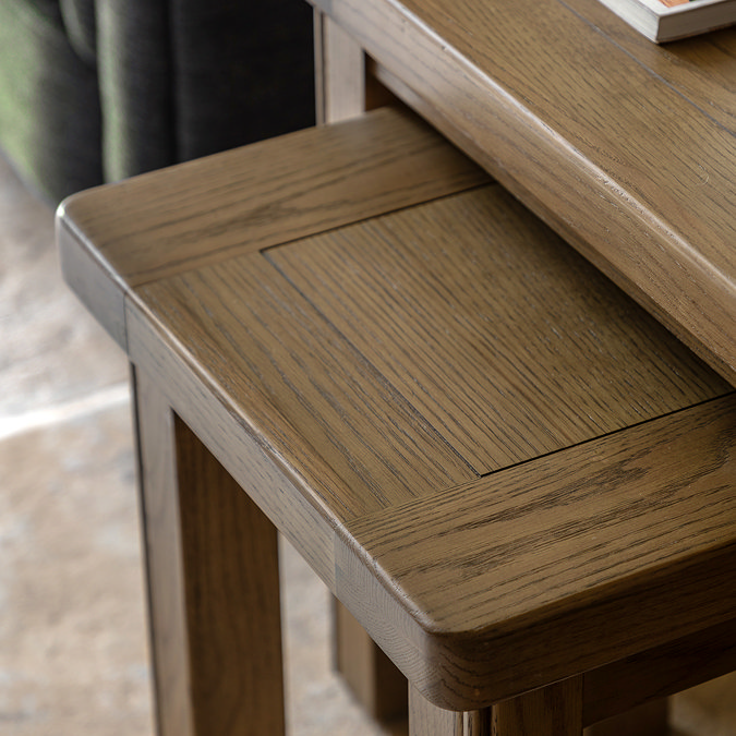 close up on smaller dark oak nesting table slotted slightly underneath larger counterpart