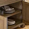 close up on dark oak sideboard with doors open to reveal shelves inside, stacked with crockery and dishes