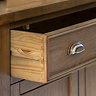 close up on wooden drawer of dark oak sideboard, pulled out to suggest storage space inside
