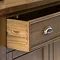 close up on wooden drawer of dark oak sideboard, pulled out to suggest storage space inside