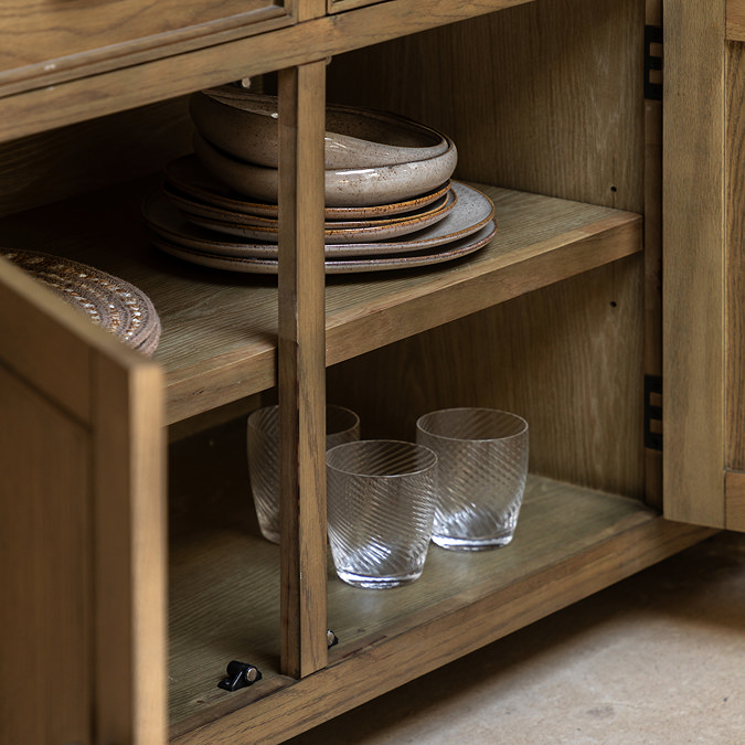 close up on open drawer of dark oak sideboard, revealing shelving space inside for glassware and crockery