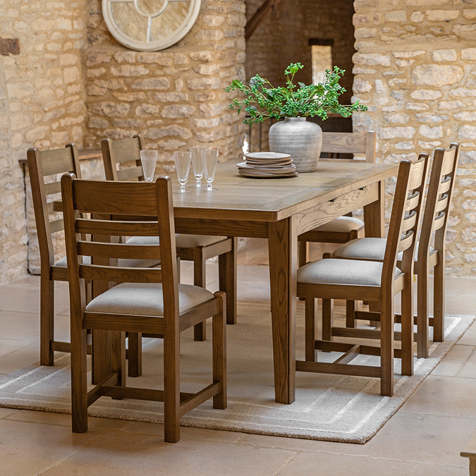 wide image of six wooden slatted dining chairs around a dining table