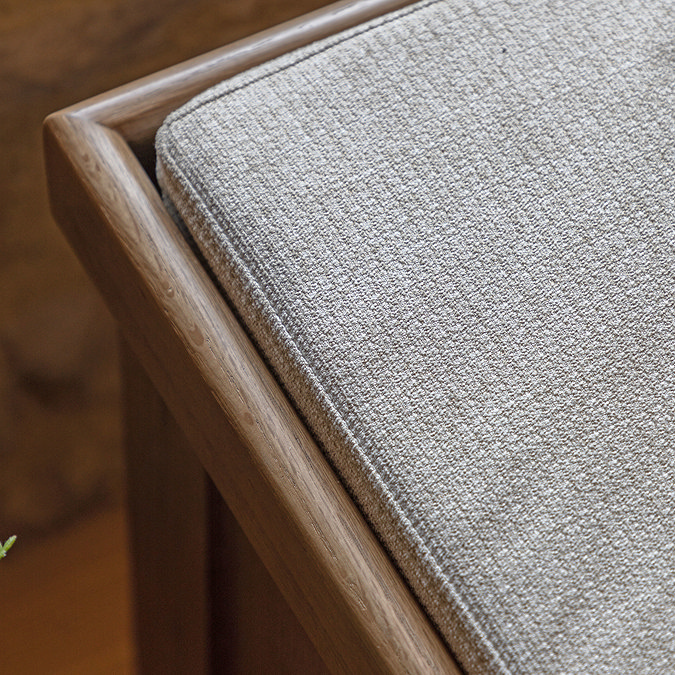 close up on fabric padding on top of dark oak storage bench