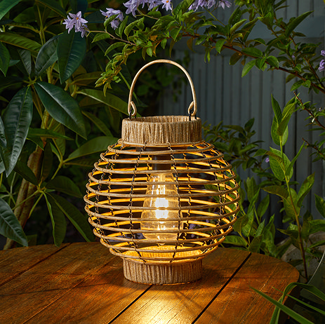 image of natural coloured round lantern with warm white bulb, on a wooden table outdoors at dusk