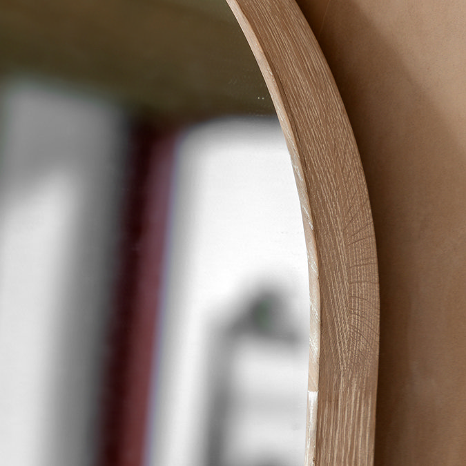 close up image of limed oak edge of top of floor mirror, focus on light colour of frame and smooth glass