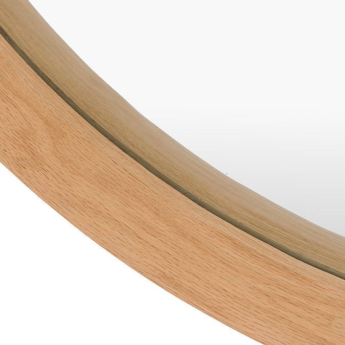 close up image of smooth oak edge of round wall mirror