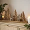 wooden tree and metal reindeer decoration, displayed amongst candles and garlands on a light oak sideboard