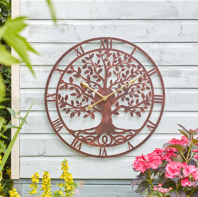 image of larger bronze wall clock on a white-painted wooden shed wall