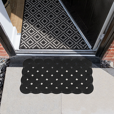 image cut out on white background of black rubber trellis scraper mat with white diamond pattern