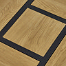 close up on top of light oak coffee table, highlighting wood grain and black metal interlocking lines