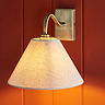 close up image on conical fabric shade of antique brass wall light