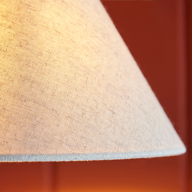 close up on fabric shade of conical wall light