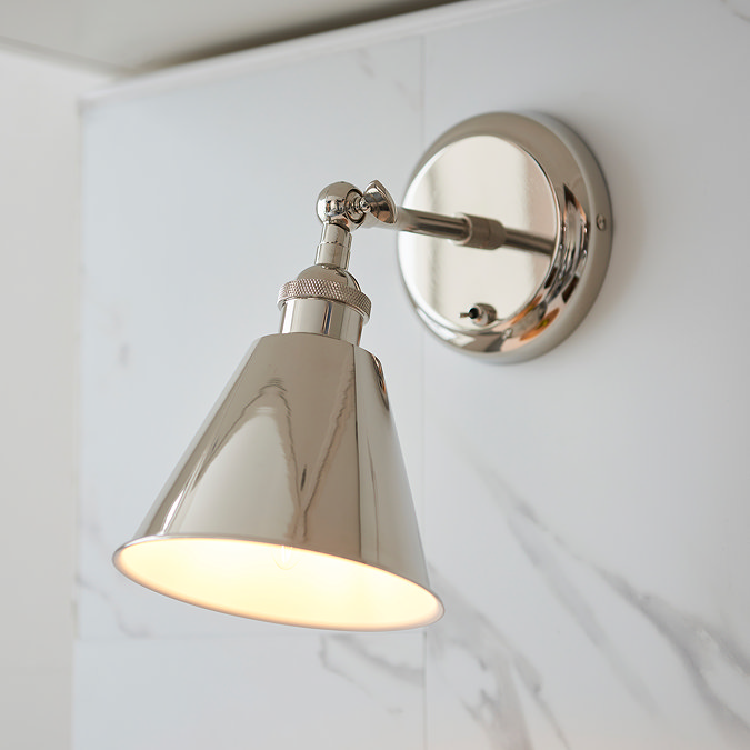 slightly zoomed in image of conical nickel wall light attached to a marble-effect kitchen wall