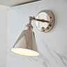 slightly zoomed in image of conical nickel wall light attached to a marble-effect kitchen wall
