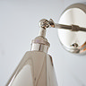 close up image of where arm fixture of nickel coloured wall light meets the conical shade