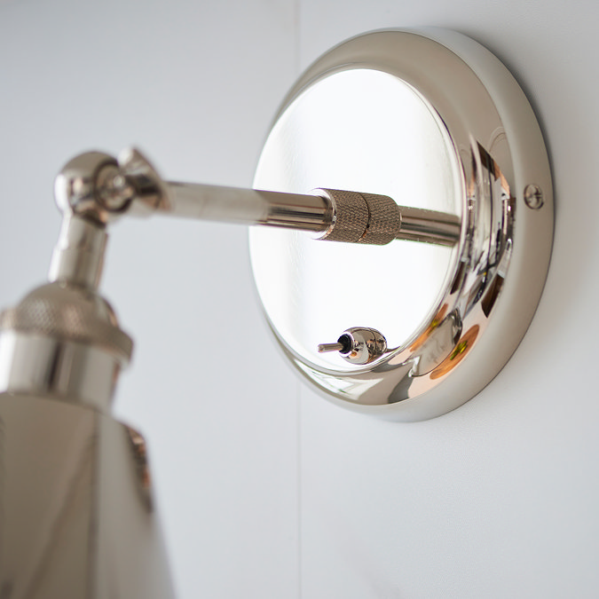 close up on circular nickel fixture of conical wall light